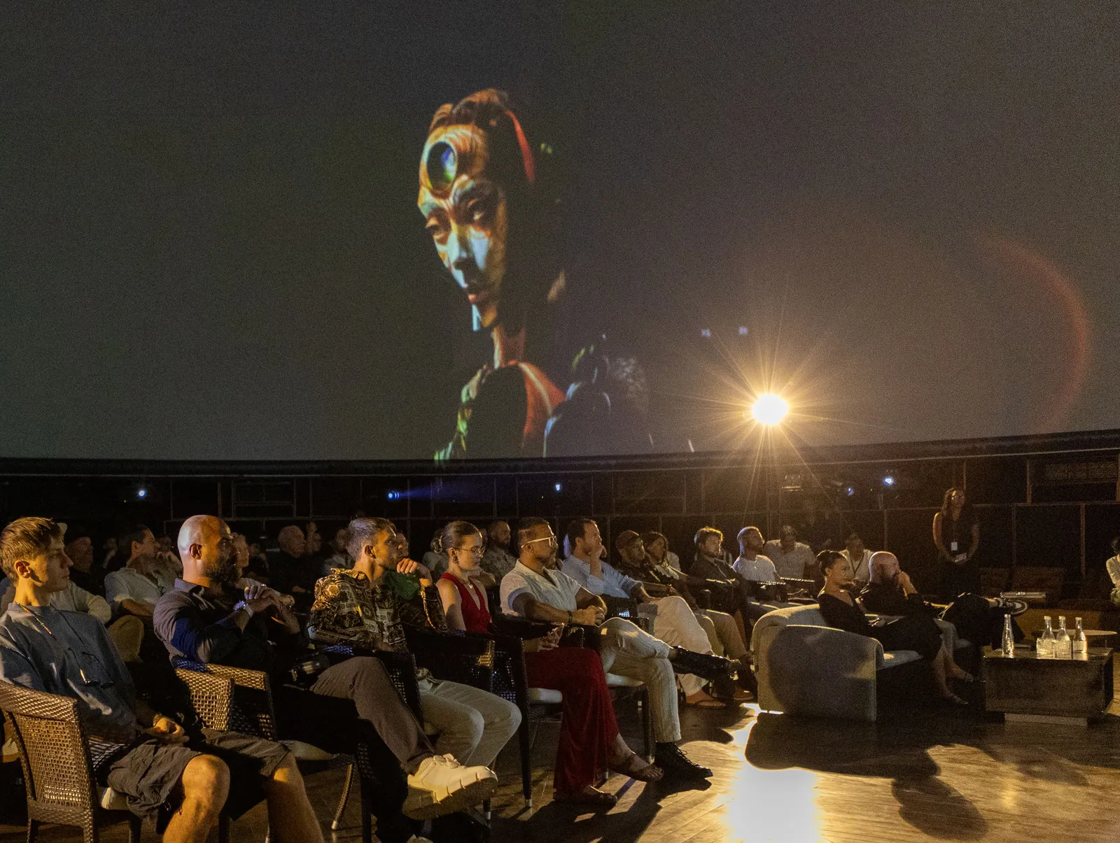 Invited guests seated beneath a projected sculpture inside the Dome